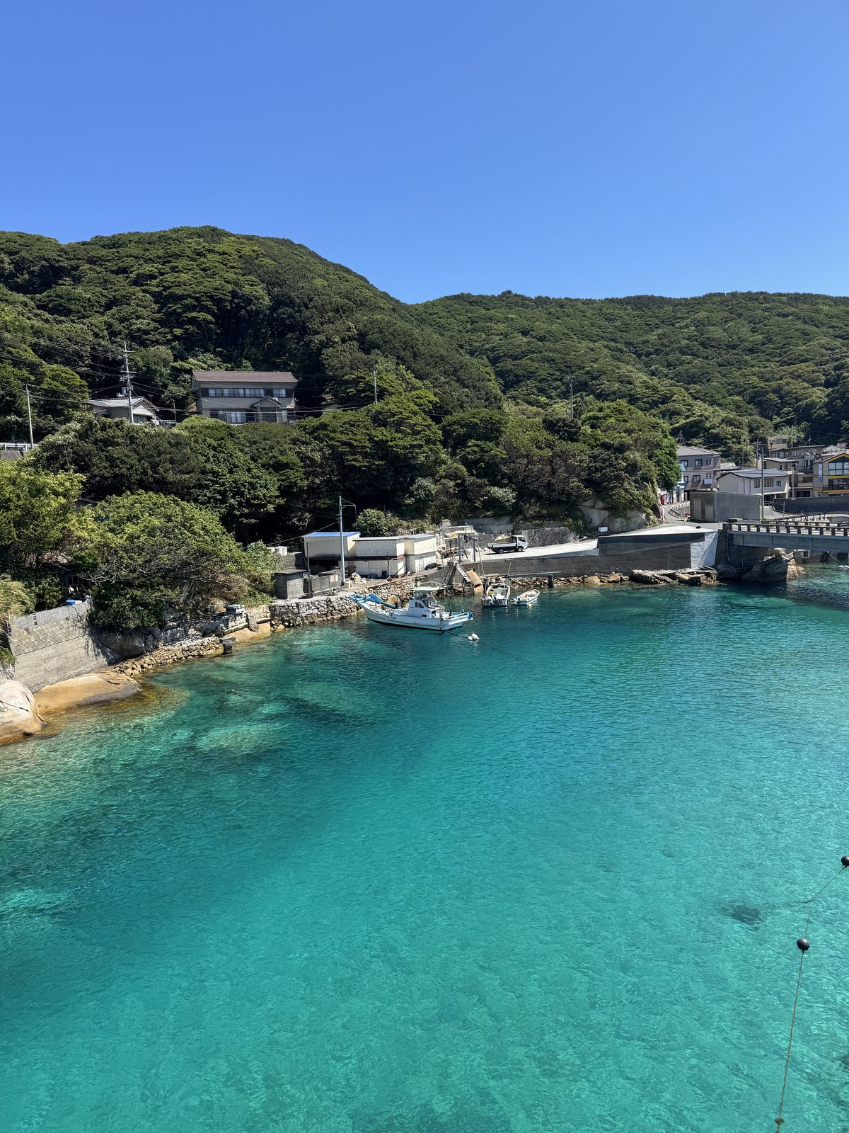 Crystal clear turquoise water at Kashiwajima, with a boat appearing to float